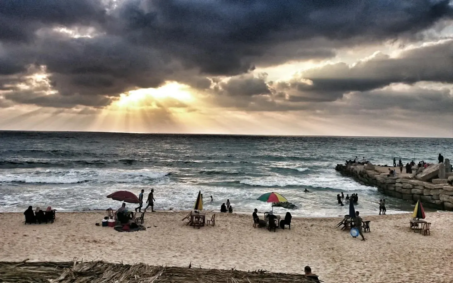 Coucher de soleil sur la plage de Gaza City, familles et promeneurs sur le sable