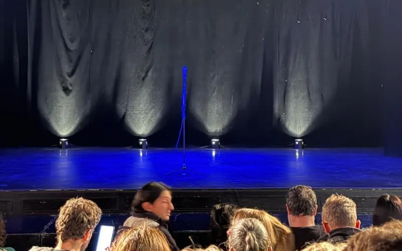 Scène éclairée en bleu et public lors d’une soirée organisée par Kulture Poza